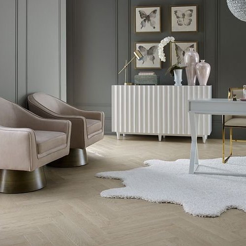 pair of luxurious arm chairs with irregular area rug on herringbone floors from Carpet Plus Flooring LLC