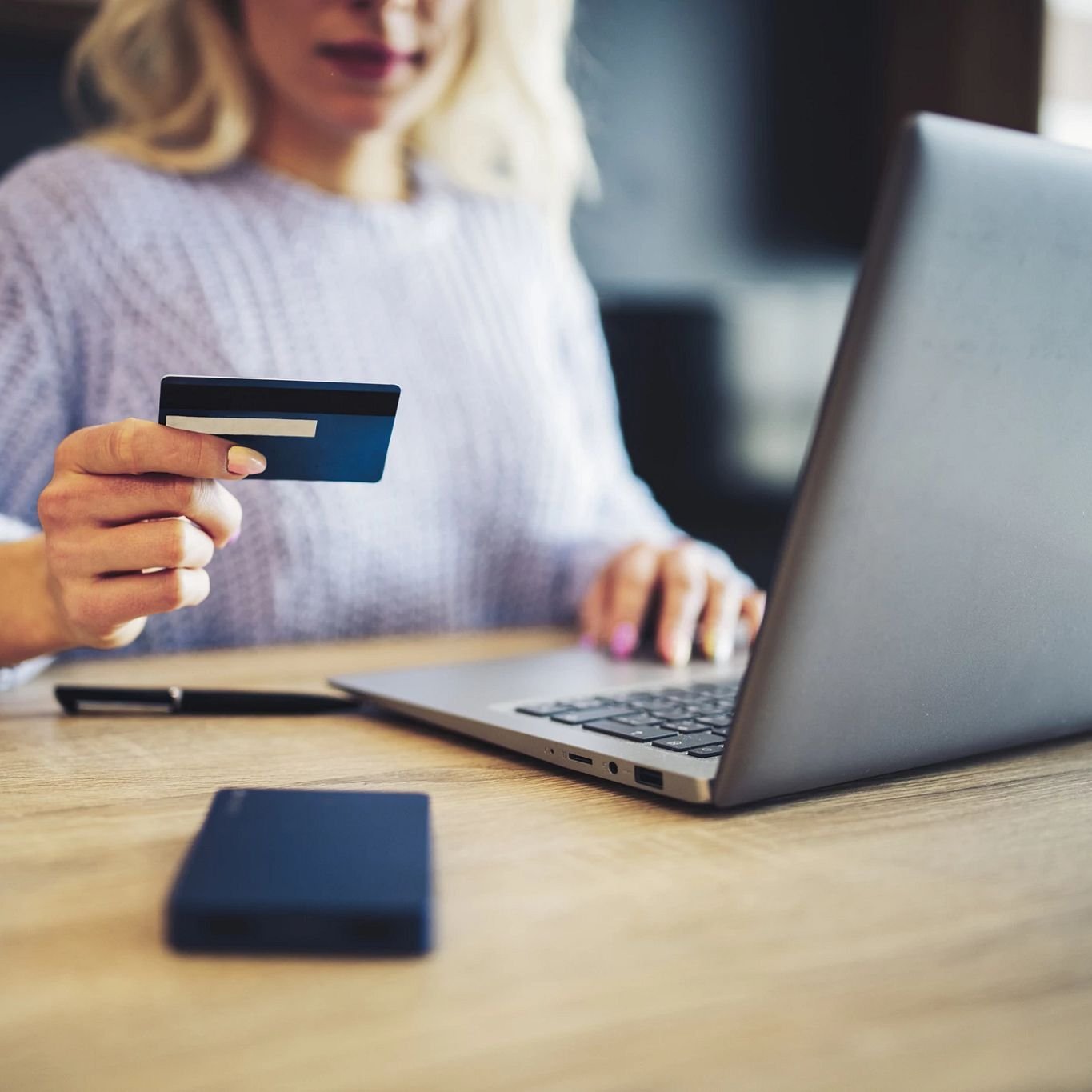 woman making purchase online with a credit card - Carpet Plus Flooring LLC