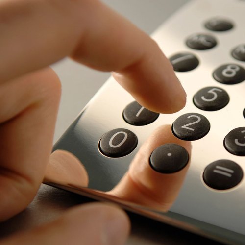 closeup of a hand using an analogue calculator