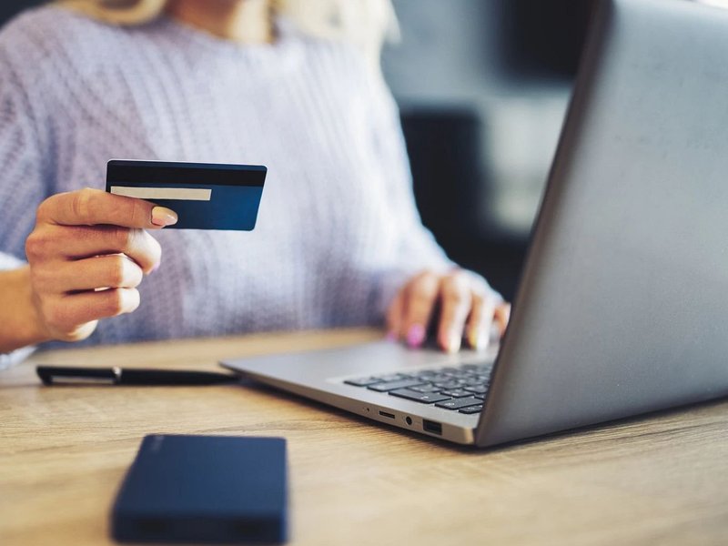 woman making purchase online with a credit card - Carpet Plus Inc