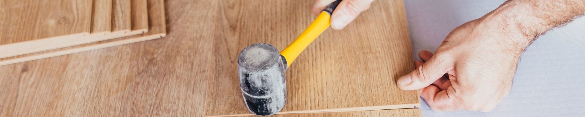installing flooring with mallet - Carpet Plus Inc