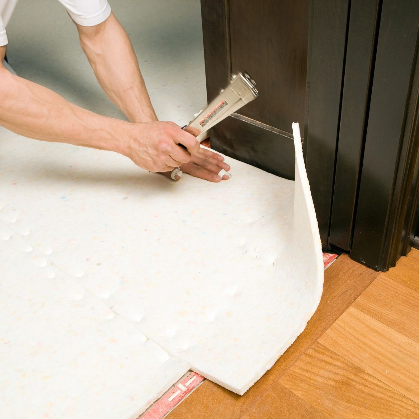 person installing underlayment - Carpet Plus Inc